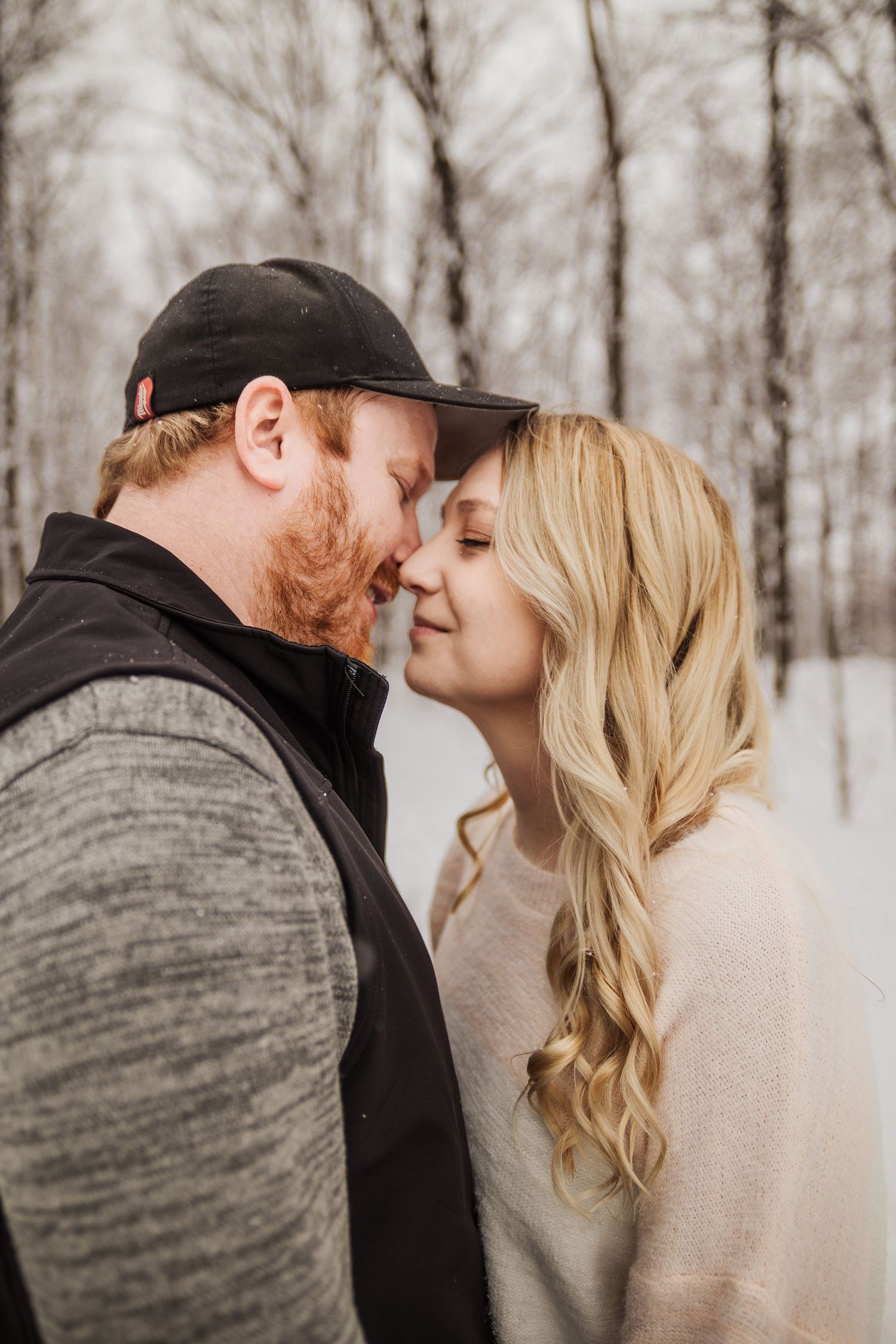 A romantic close-up photo of a couple about to kiss during their winter engagement session.