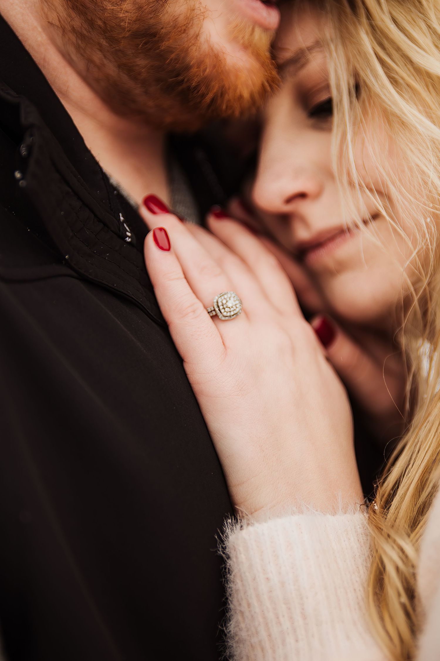 A close-up shot showing an engagement ring while a couple shares an intimate moment.