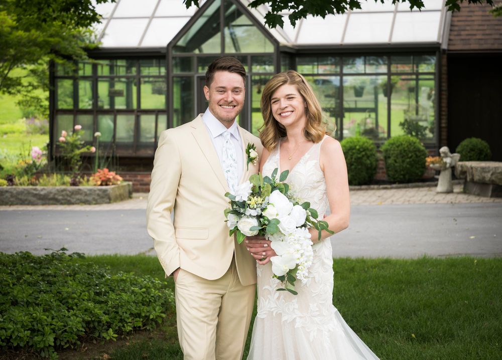Wedding couple portraits outdoors in a garden setting with lush green landscaping and natural lighting.