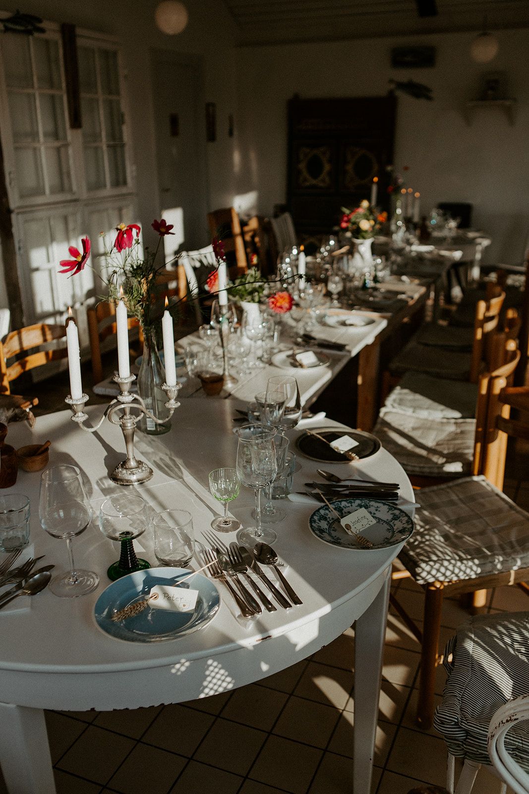 charmerede og intim bordopdækning med forskellige borde, stole og service i en lille restaurant på tæt havnekanten i nysted
