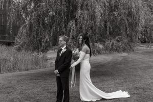 Black and white wedding photo under a weeping willow tree.