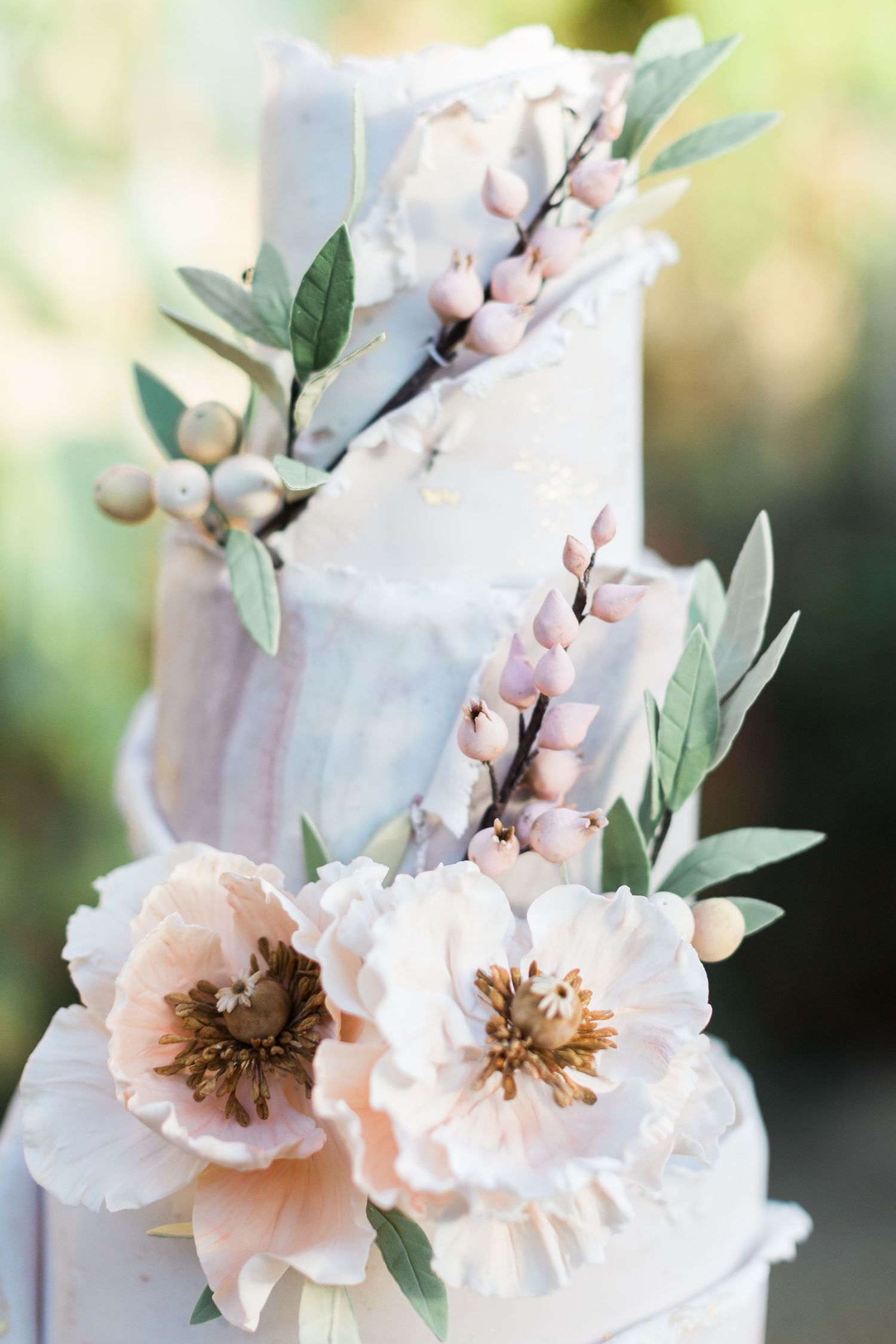 Elegant wedding cake decorated with soft peach flowers and delicate green foliage and mocha moose accents Merriscourt Hayley Elizabeth