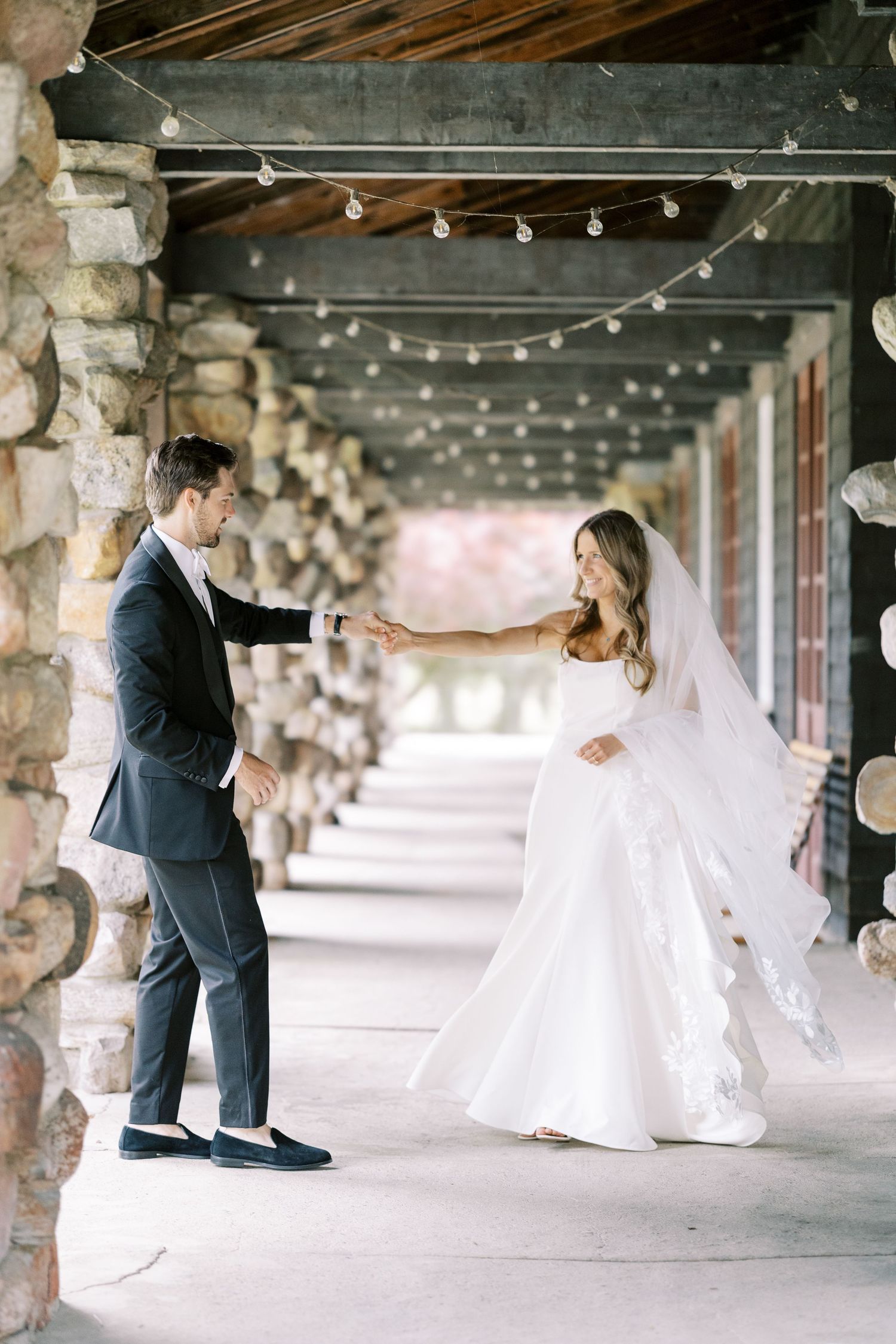 Bride and groom at the auditorium with stone pillars on Lake George at Silver Bay YMCA.