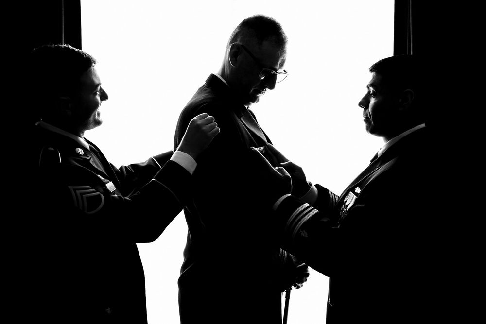 Dramatic silhouette of three figures in tense confrontation against dark background.