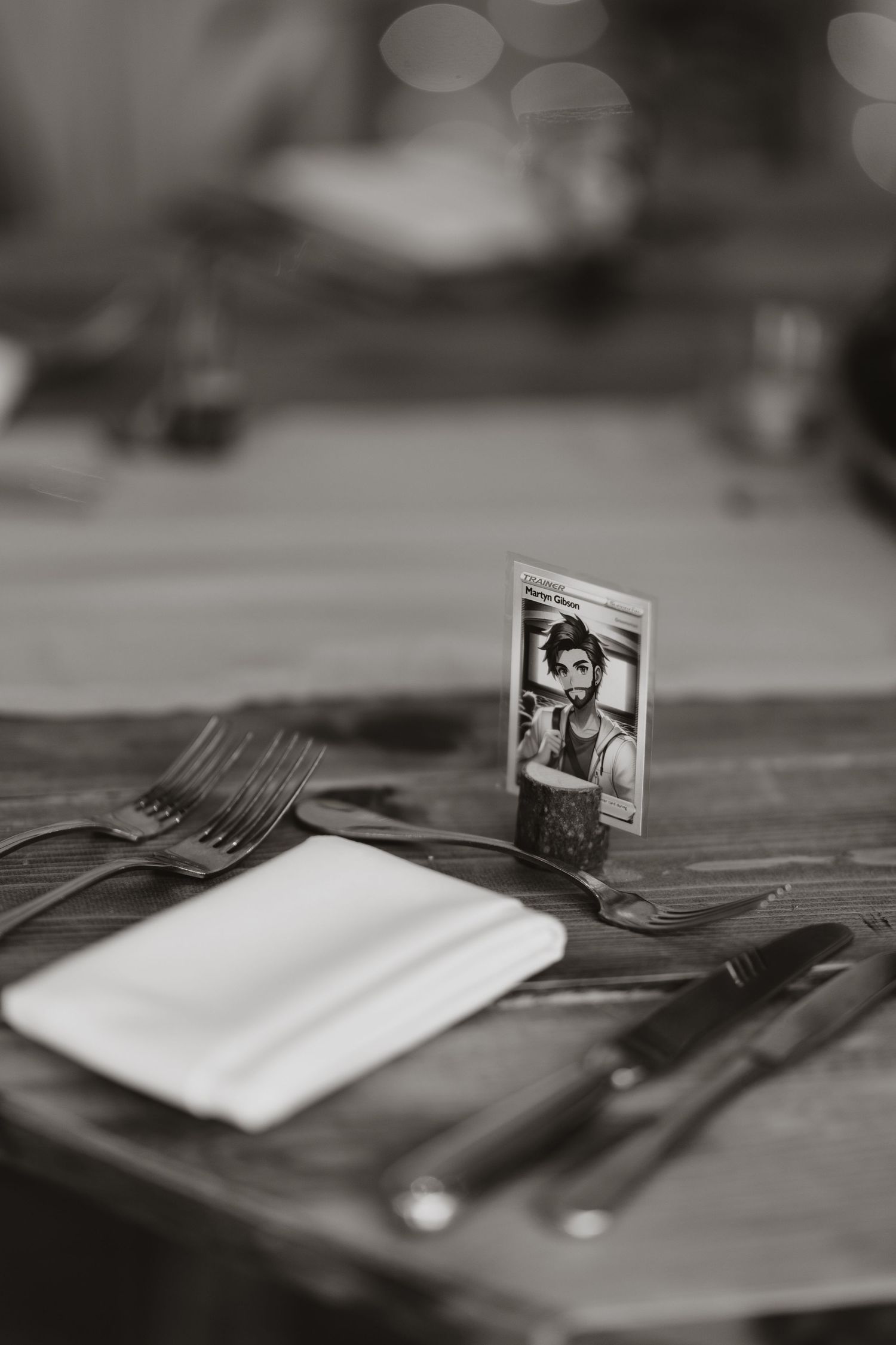 A black and white photograph is propped up on a table place setting with silverware and a napkin.