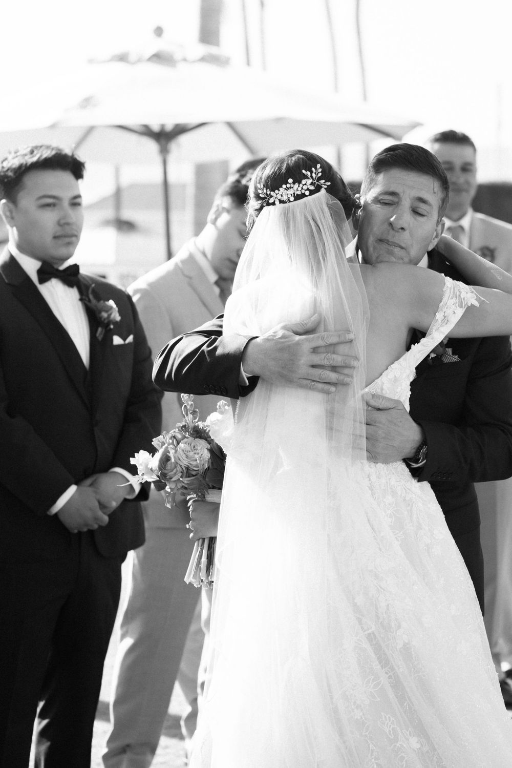 An emotional moment during a wedding ceremony captured in black and white photography.