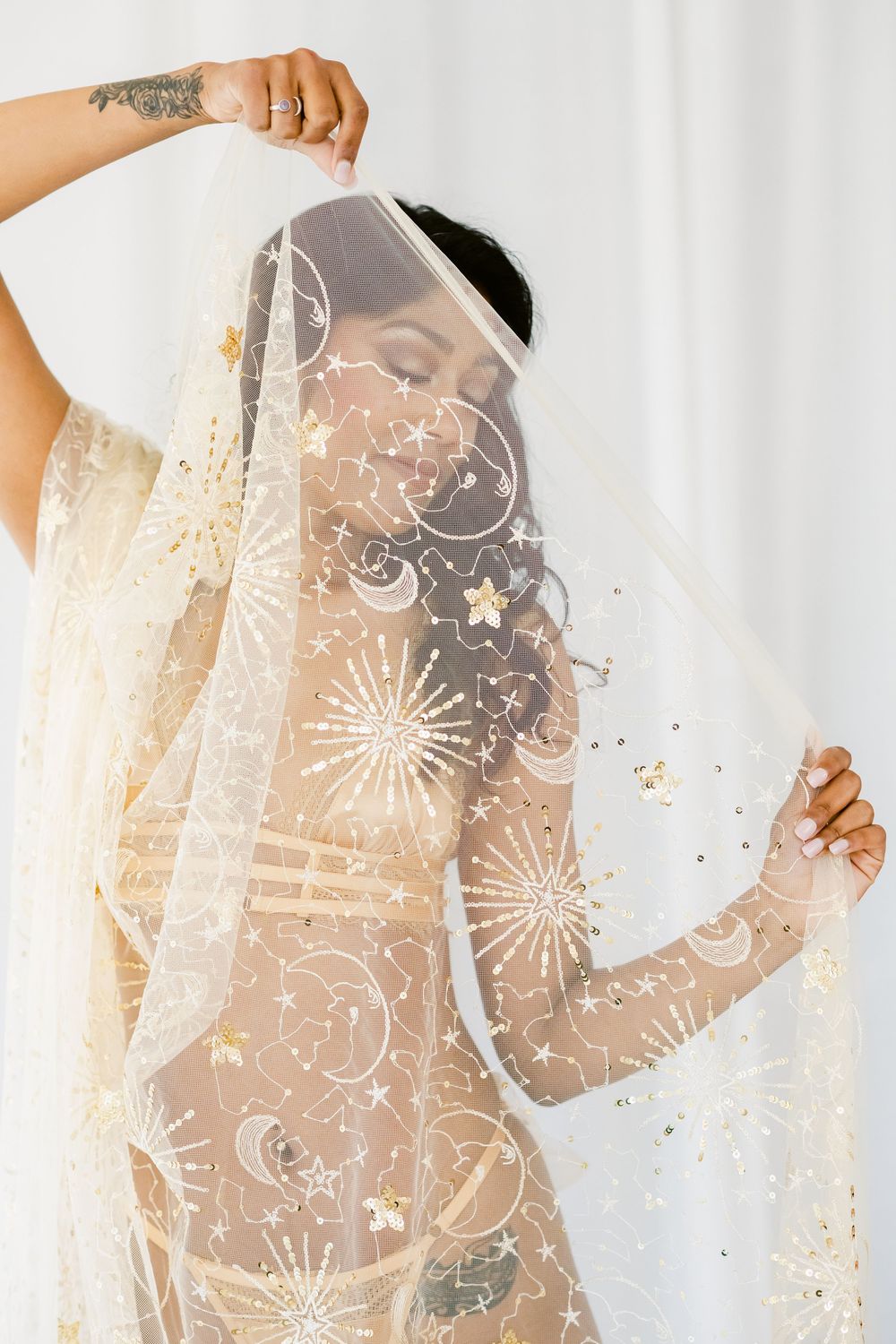 Four abstract photographs showing delicate lace overlays with floral patterns creating ethereal shadows against a light background.