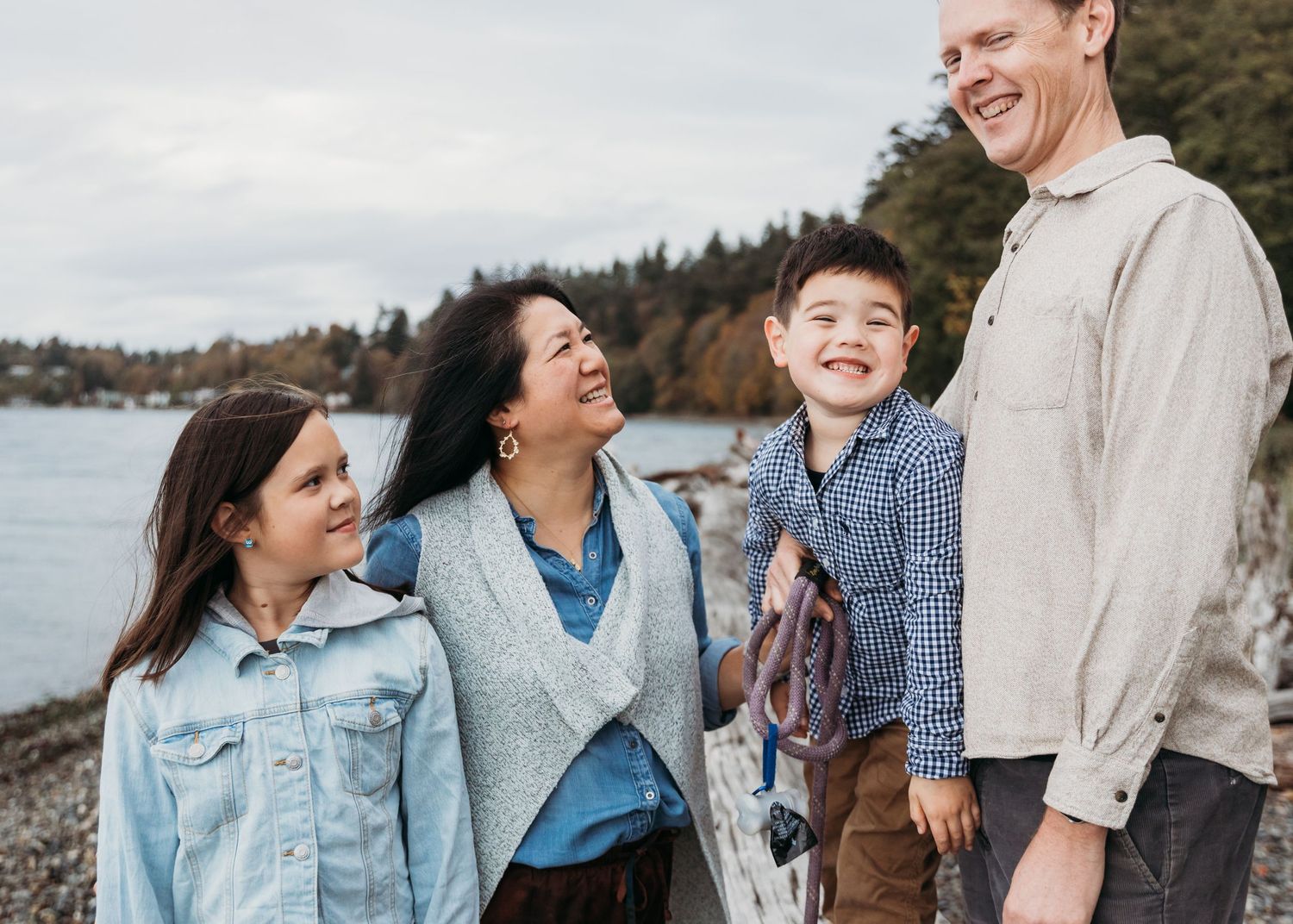 A group of people walking and laughing together on a waterfront path during an outdoor photography session.