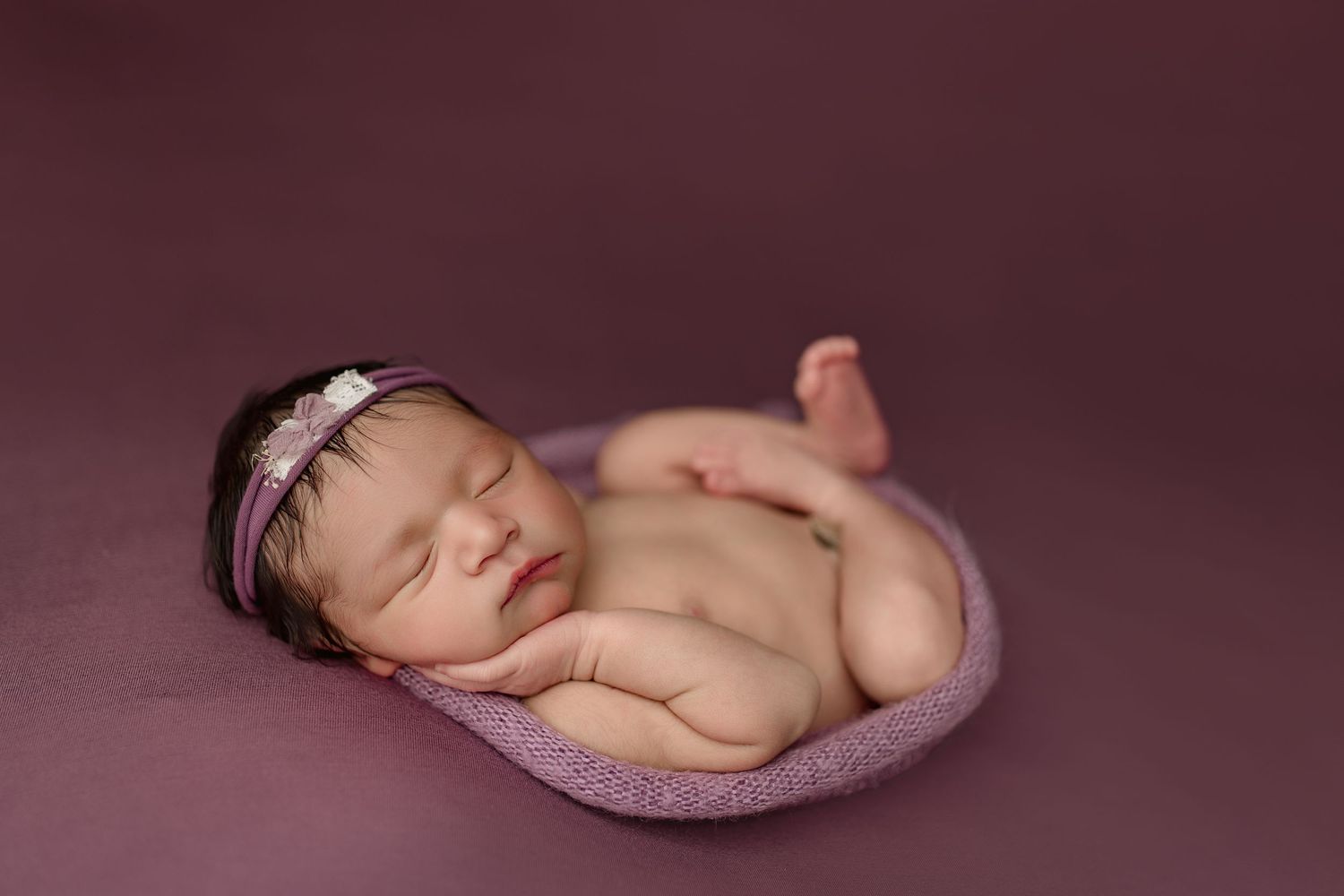 A series of peaceful sleeping newborn baby photos arranged in a row showing different resting poses on soft fabric.