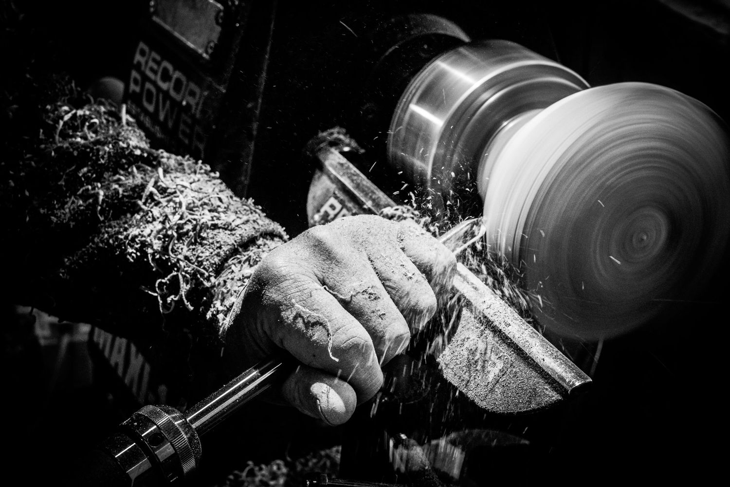 Woodturner crafting a wooden bowl on a lathe, photographed by simon robertson