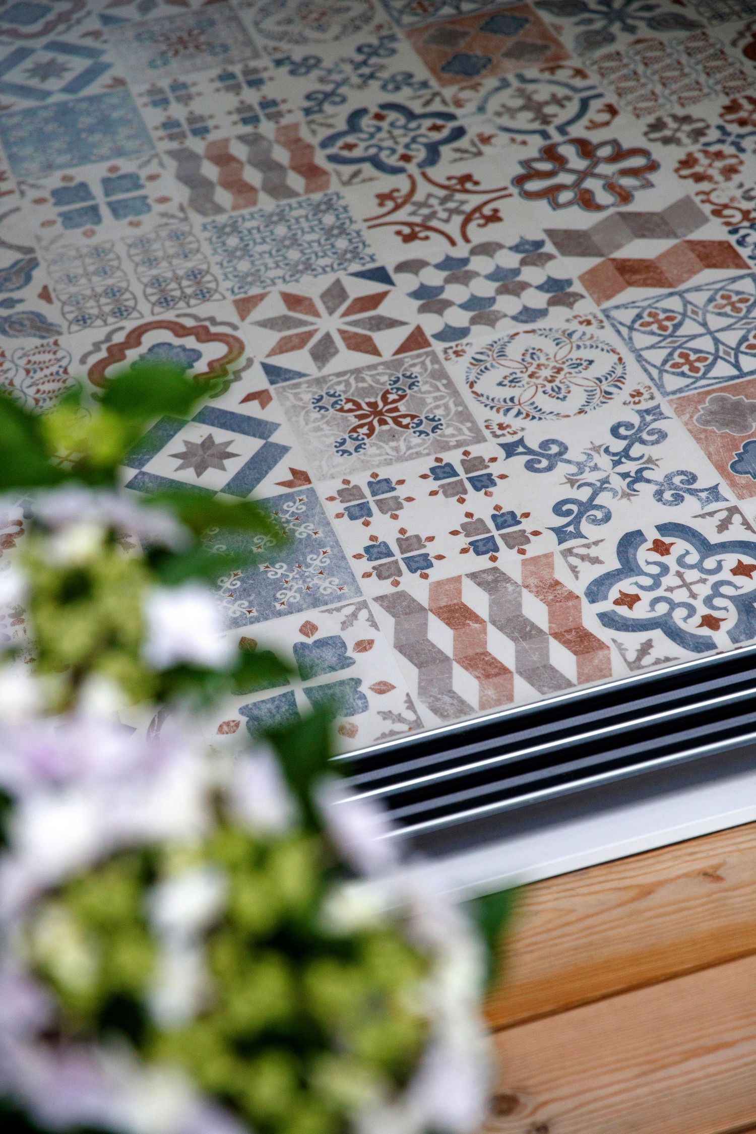 Decorative tile flooring featuring intricate blue and terracotta patterns in a modern interior space.