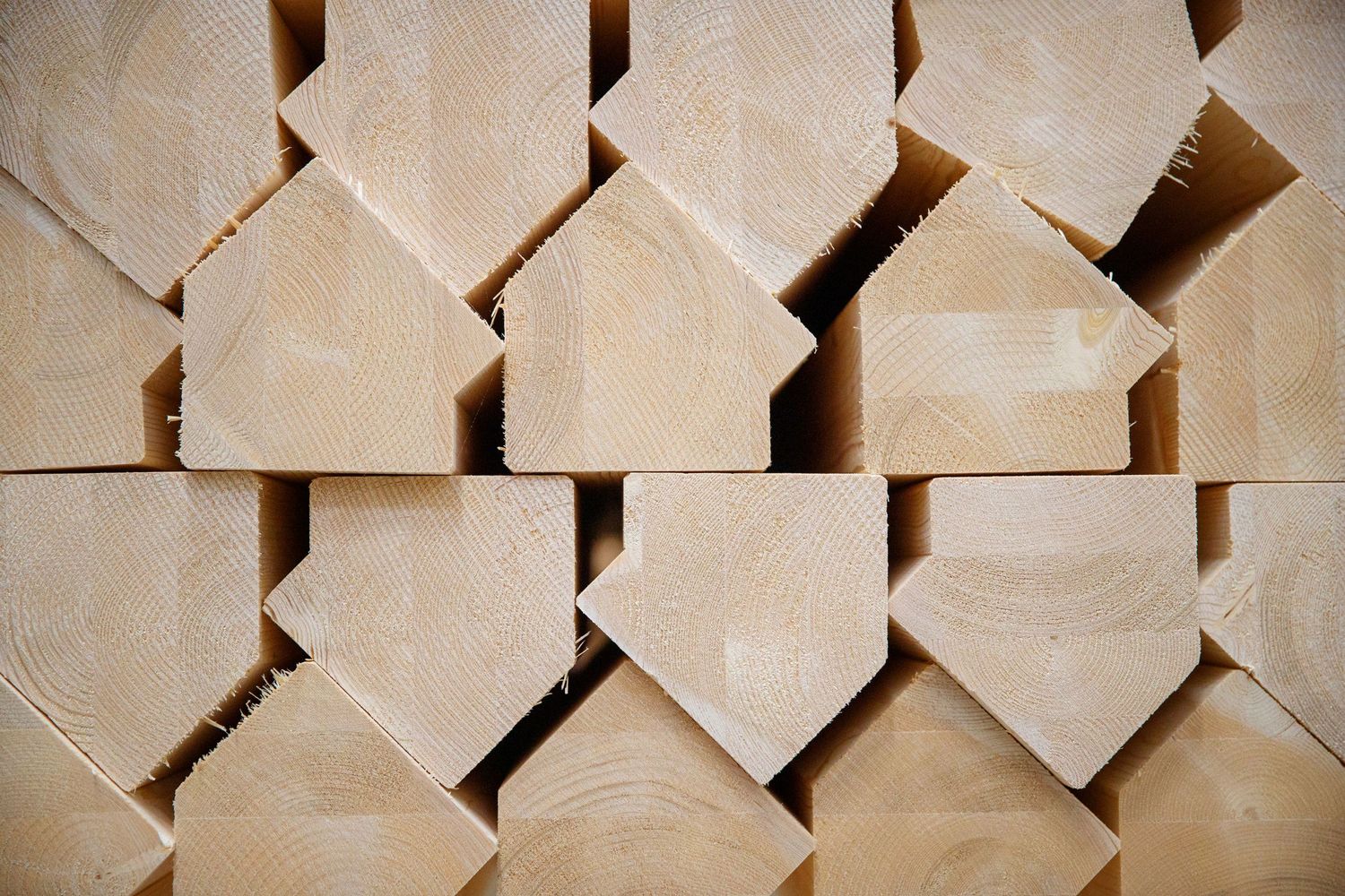 Geometric pattern of stacked wooden house-shaped blocks in beige tones.