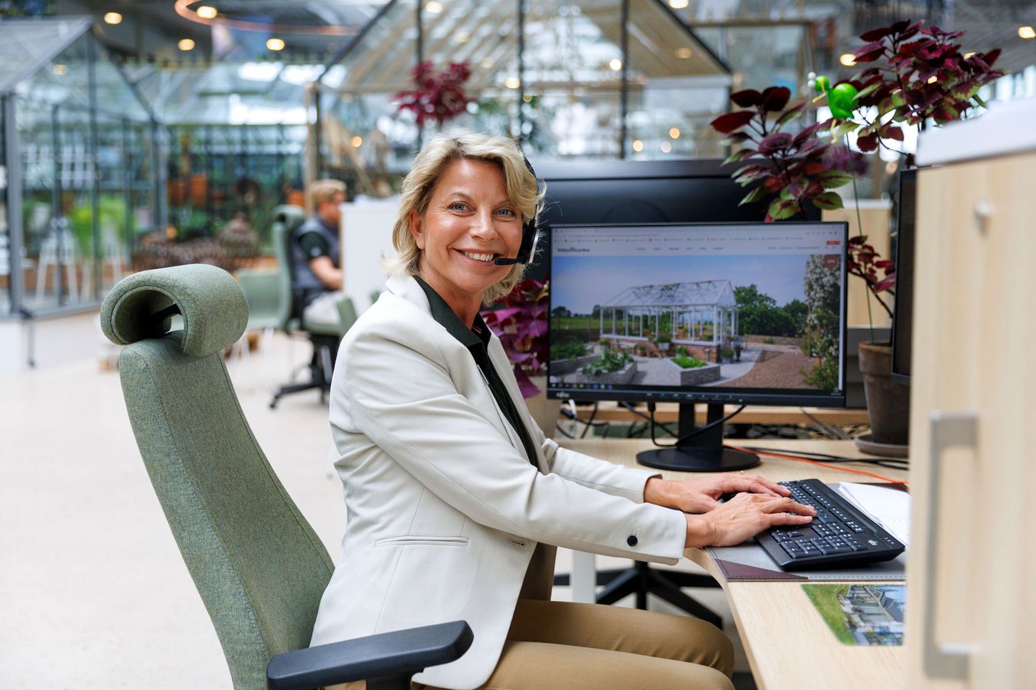 Sales person with a computer in a modern office space with natural lighting.