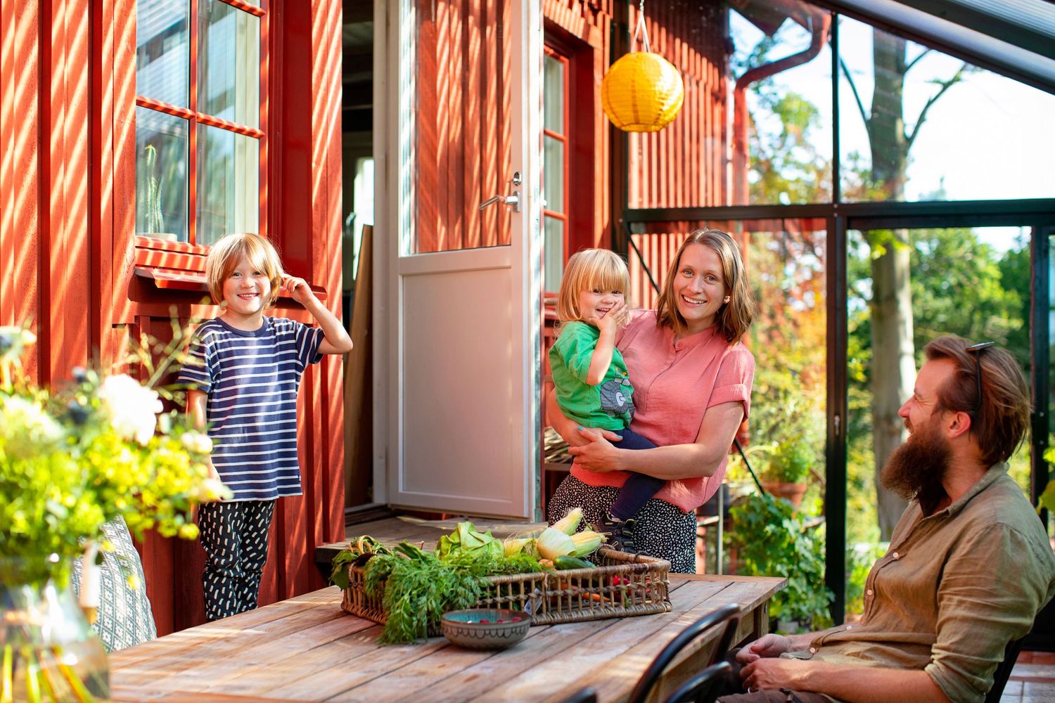 A family gathering in a sunlit conservatory with playful moments and natural light.