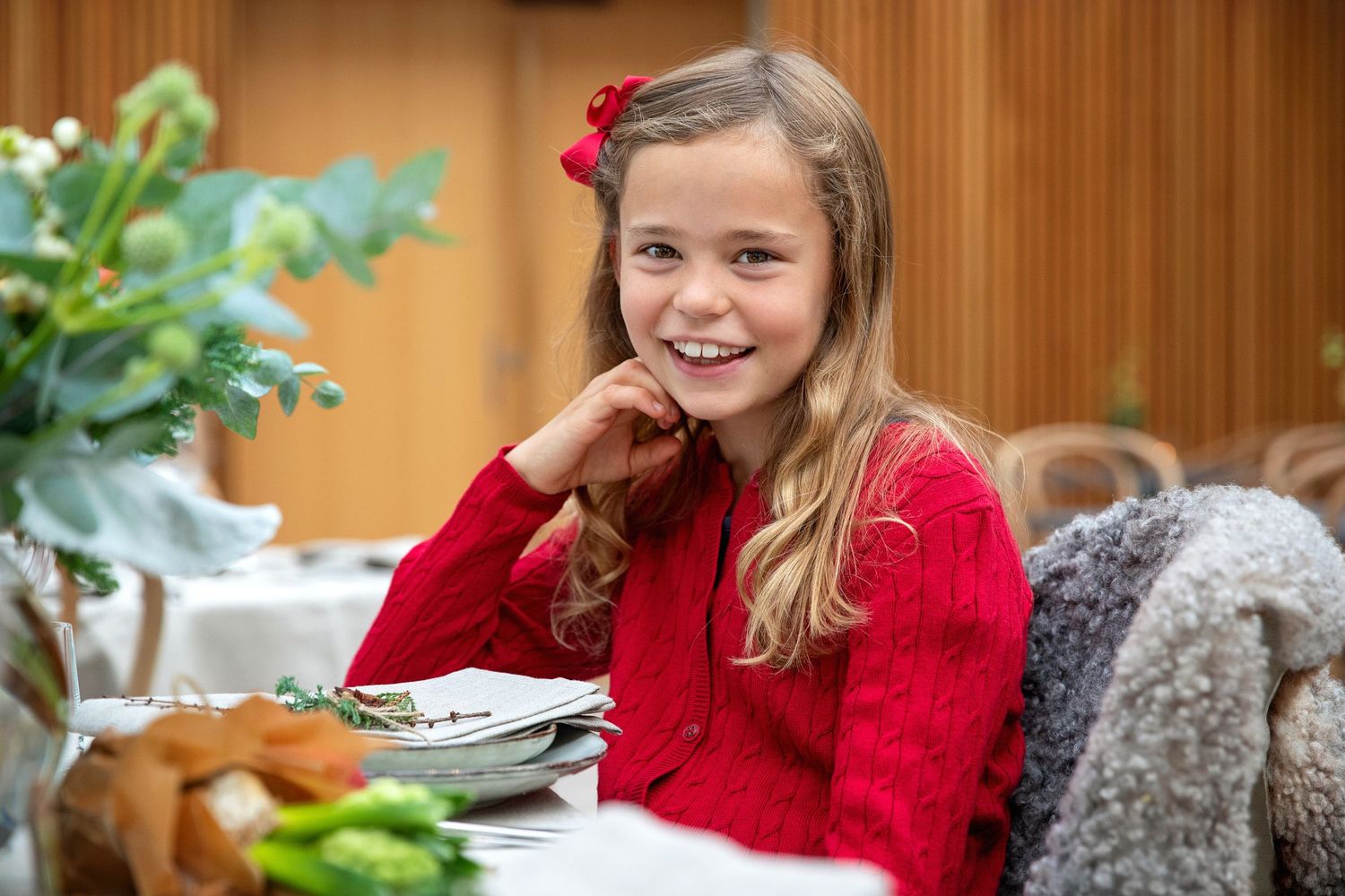 A cozy indoor dining scene with a warm red sweater and Christmas festive table setting.