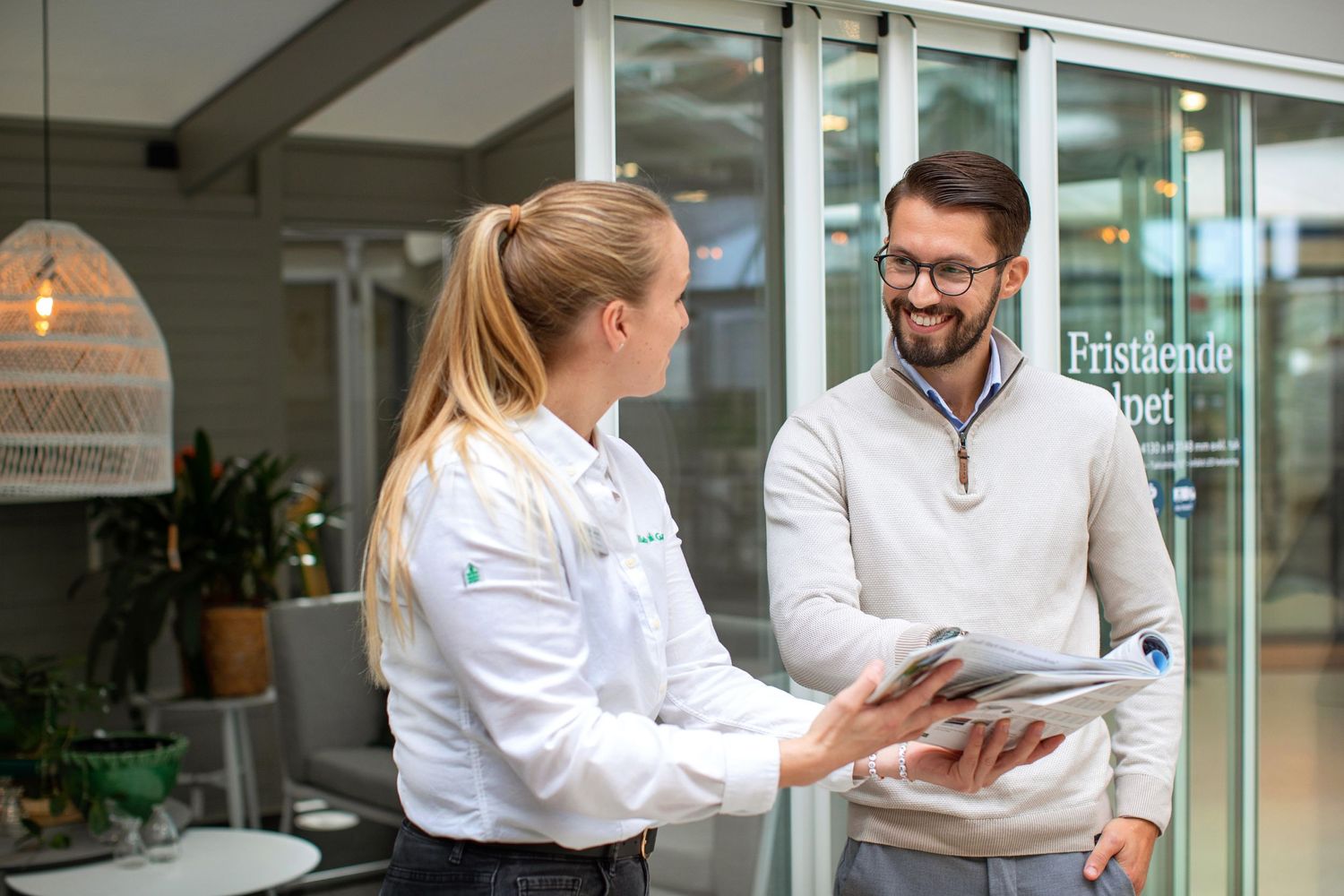 Greenhouse showroom staff and client reviewing documents and discussing products.