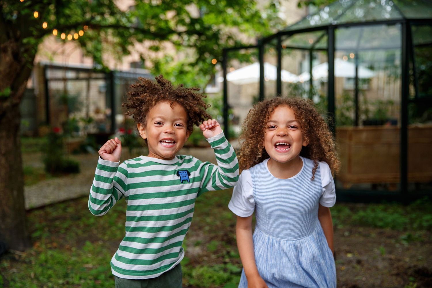 Children playing and laughing outdoors in a natural setting.