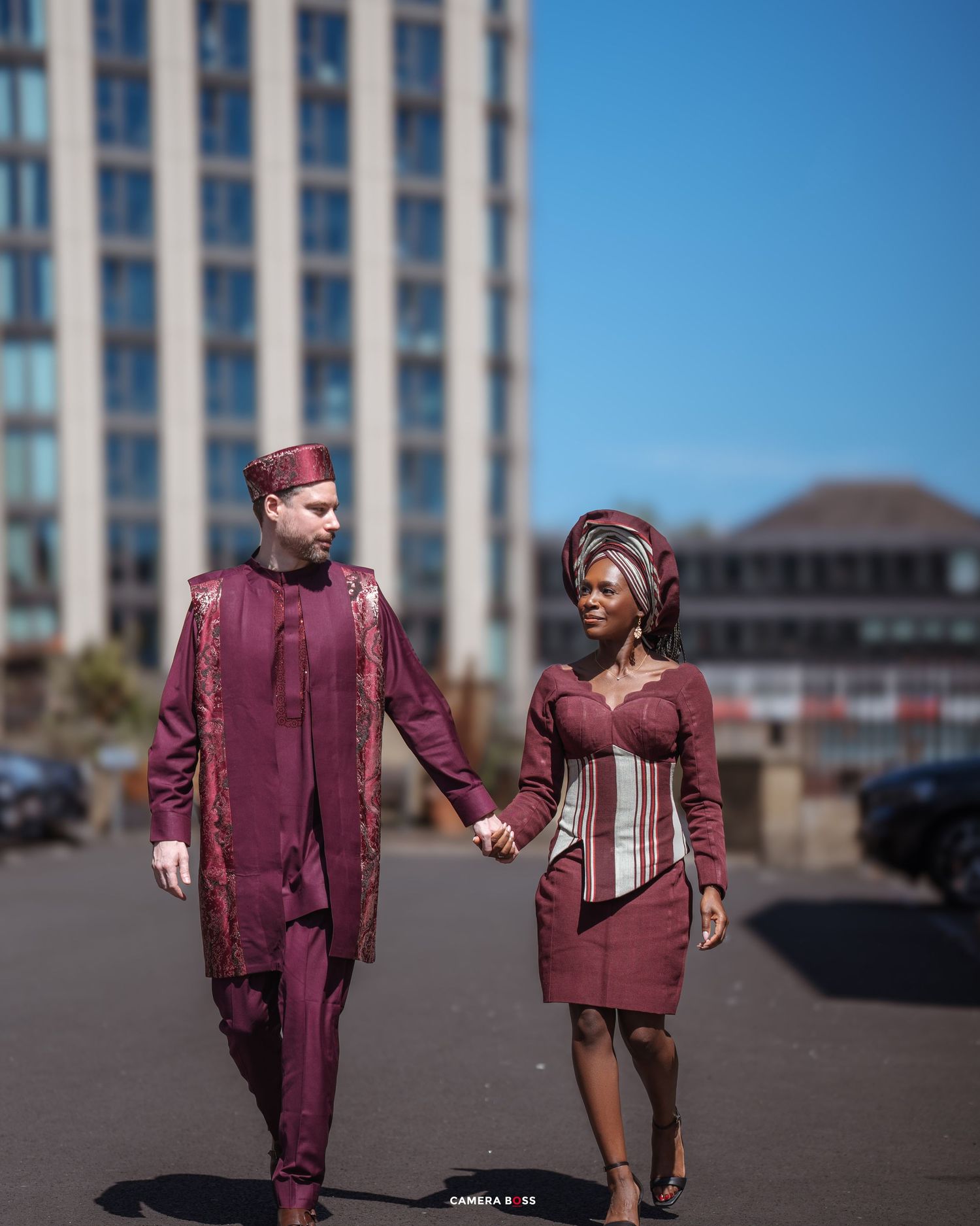 Five consecutive photos showing a couple in matching burgundy outfits walking and holding hands on a paved surface.