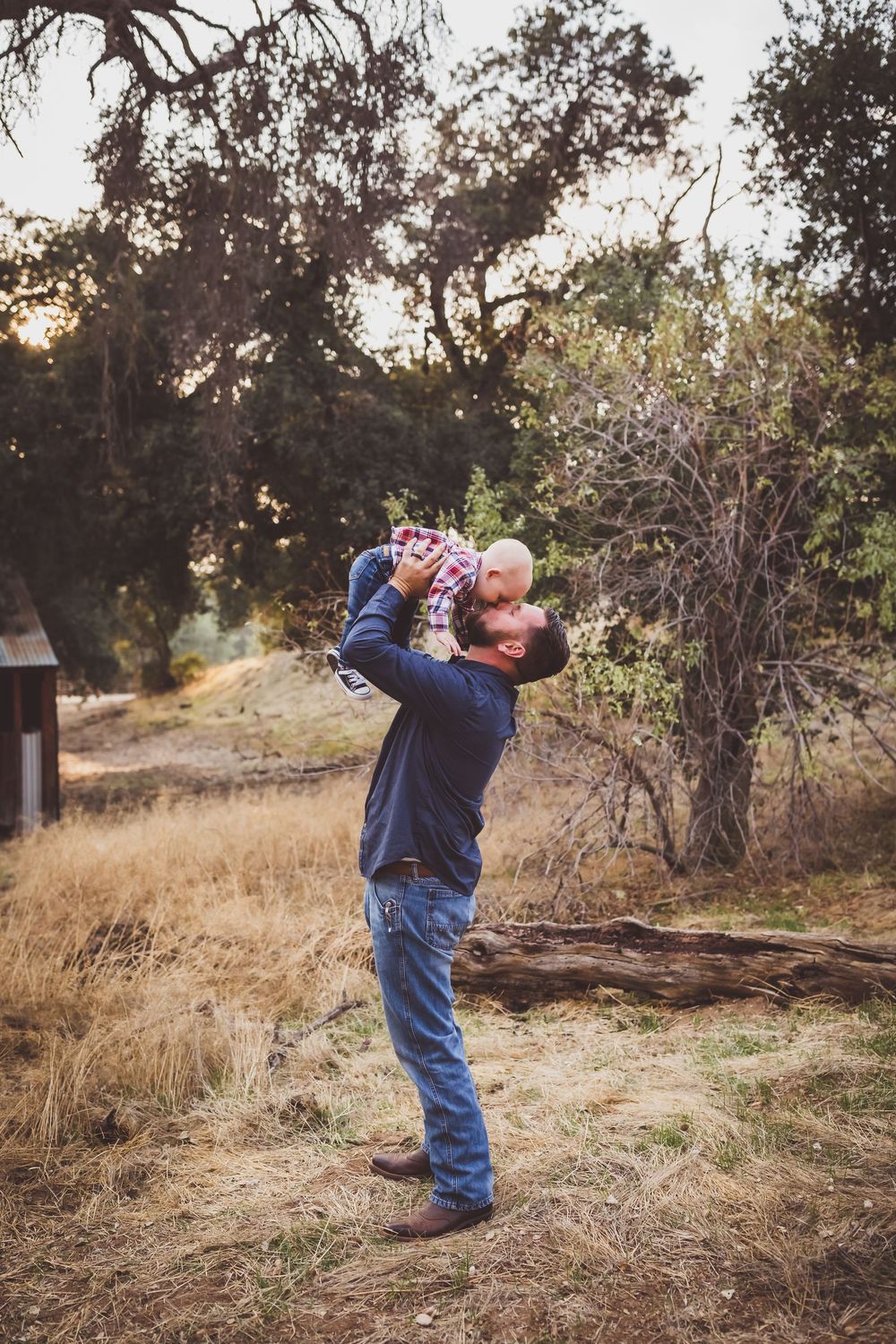A joyful moment captured against a backdrop of oak trees and golden afternoon sunlight.