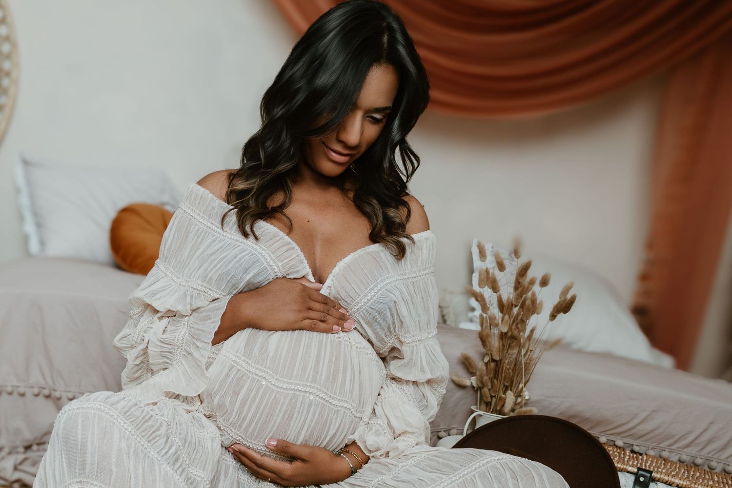 Sesión de fotos de embarazo en valencia en un estudio con decorado boho y con vestuario incluido