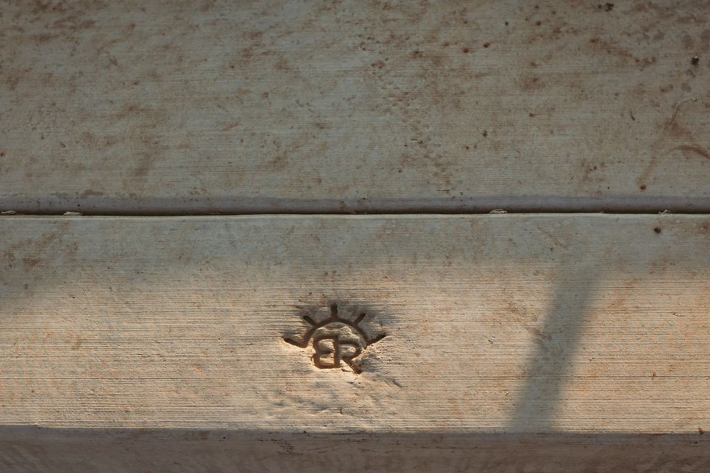 Close-up of weathered wood plank with etched initials.