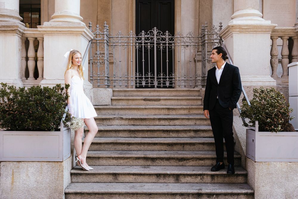 Bride and groom share intimate moments on marble stairs during an elegant Mediterranean wedding photoshoot.