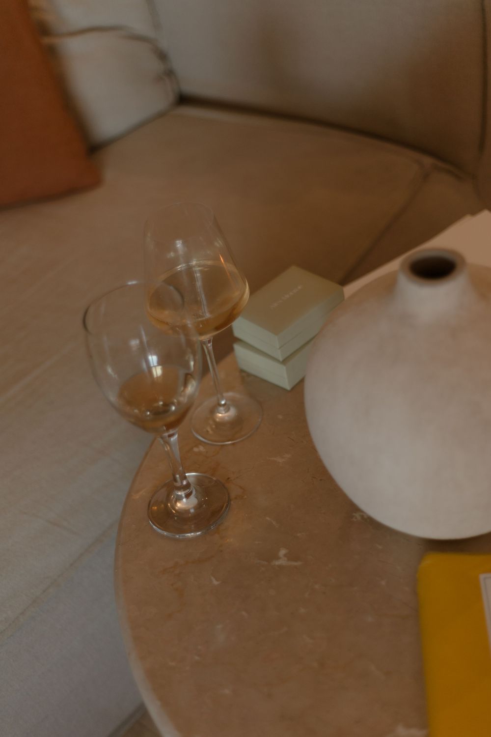 Wine glasses and table settings visible on a brown surface in dim lighting.
