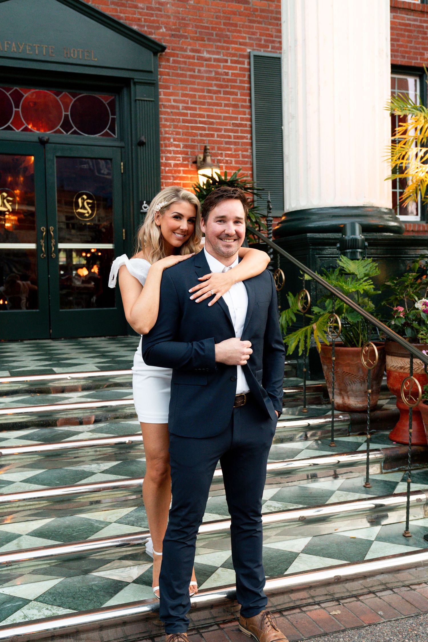 Jessica Paige Photo Co. Best San Diego Wedding Photographer. Playful couple poses on decorative steps of historic building entrance.