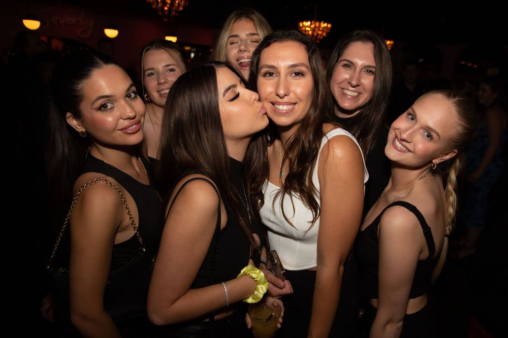 A group of friends having fun and posing together at a dimly lit nightclub or party. Photography Gold Coast