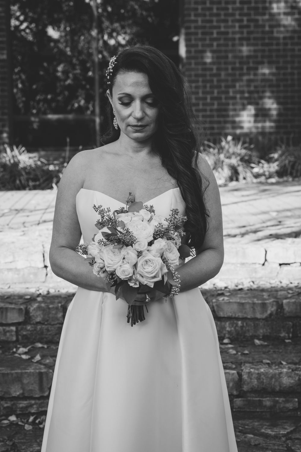 A bridal portrait featuring an elegant white bouquet and strapless gown.