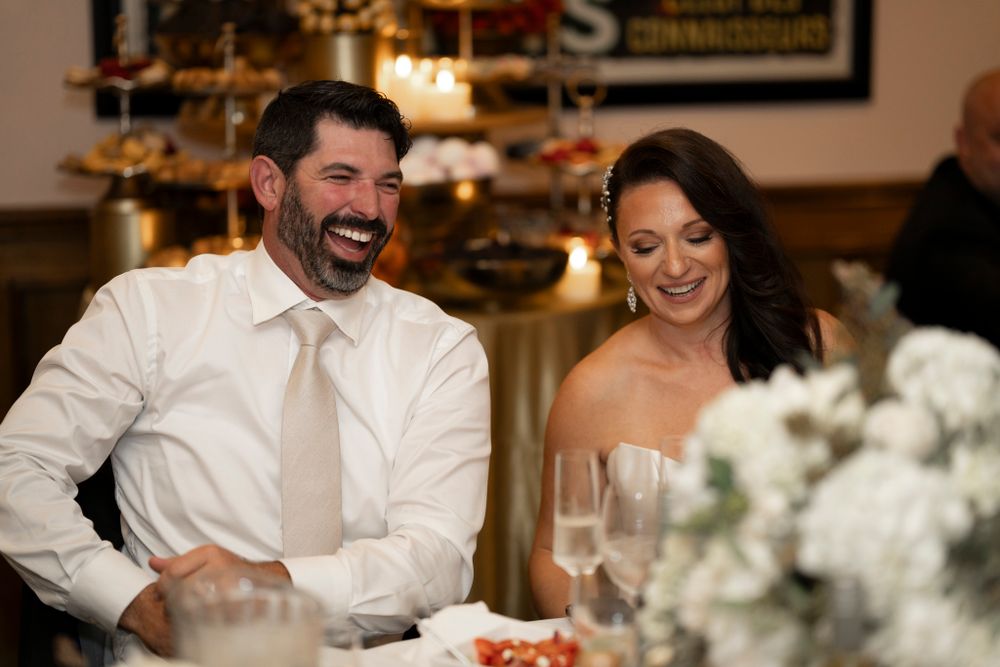 Reception dinner scene with table decor featuring white floral centerpieces.