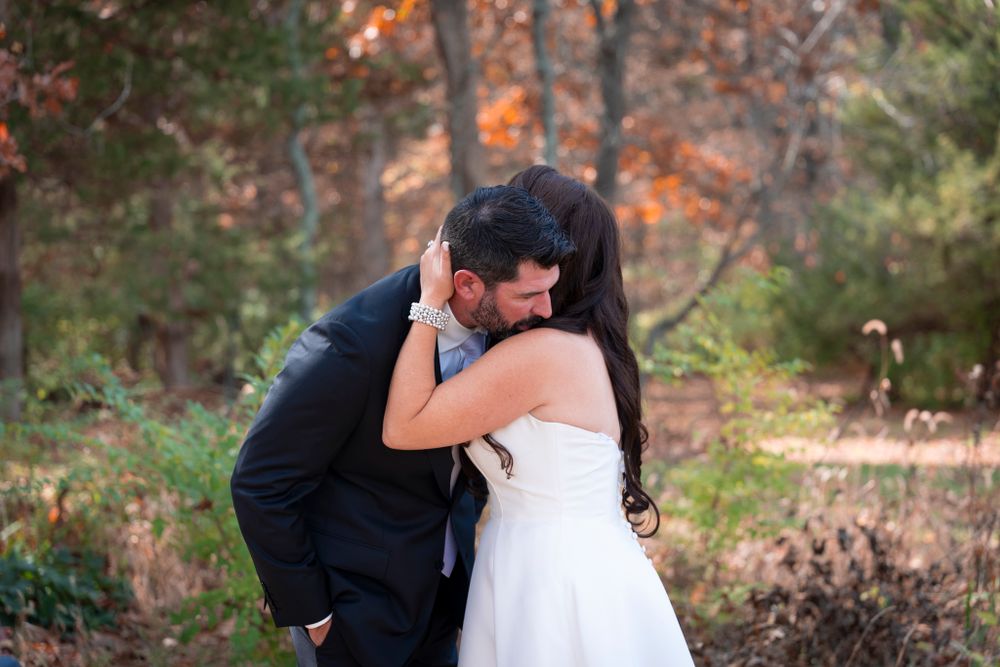 Romantic embrace between newlyweds surrounded by fall foliage.