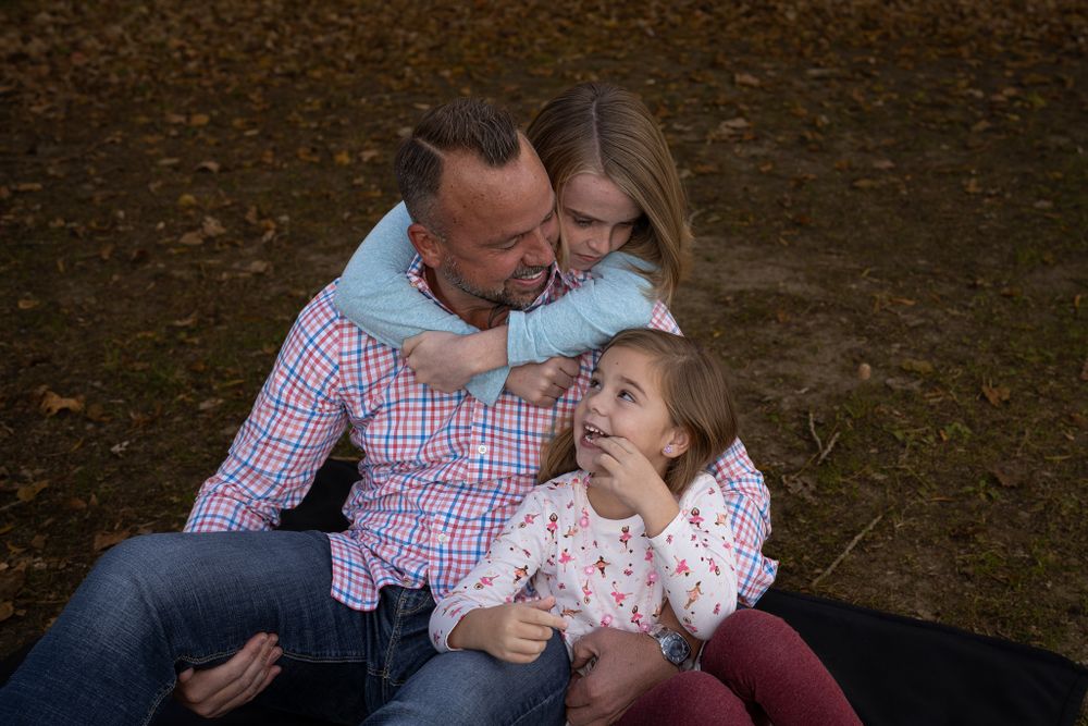 A family cuddles close together during an outdoor autumn photo shoot.