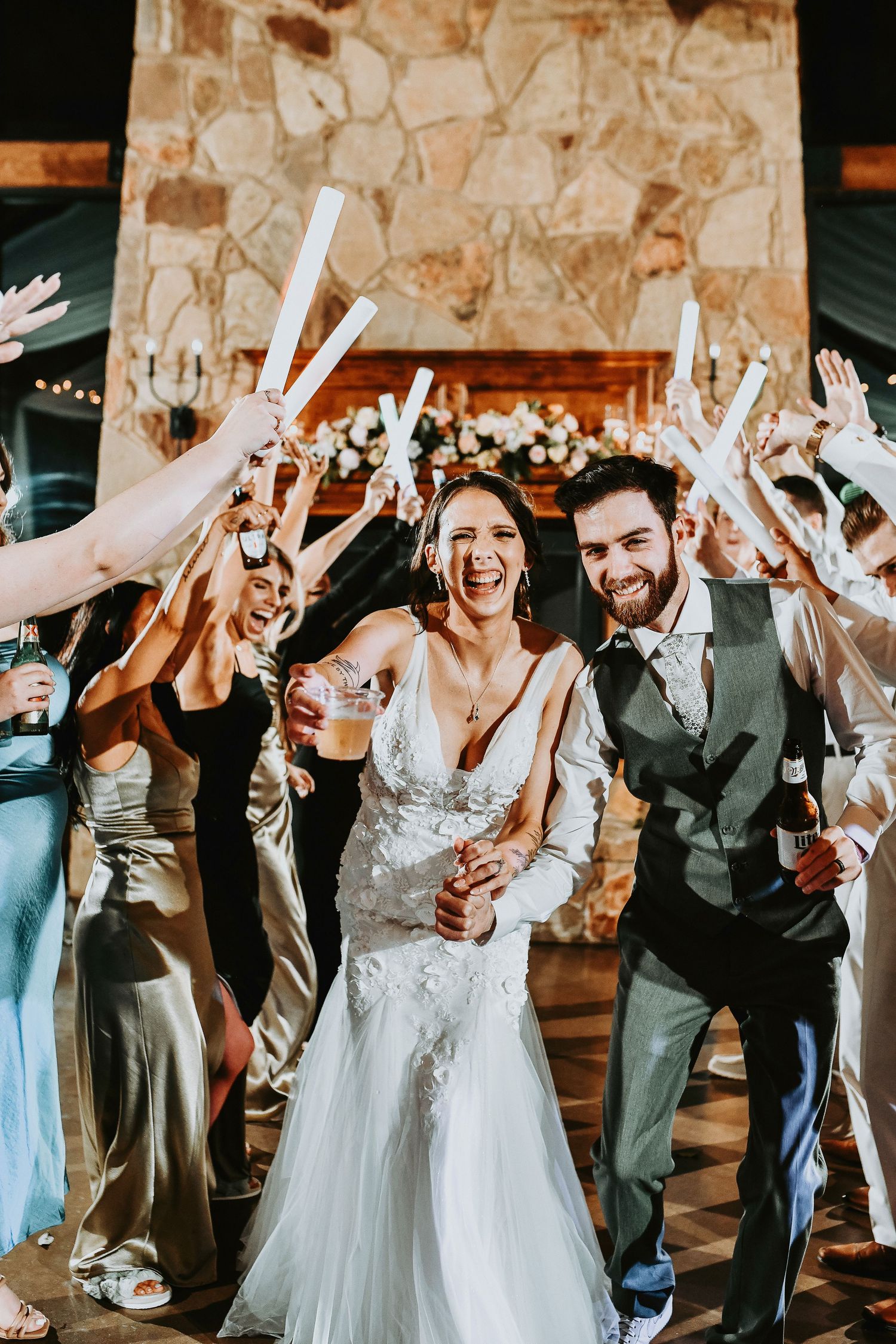 bride and groom party through a dance tunnel of friends and glowsticks as they dance during their wedding reception