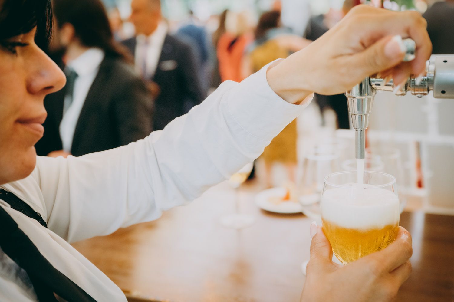 Alguien sirviendo una cerveza dorada en un vaso en un evento del Palacio de Villabona.