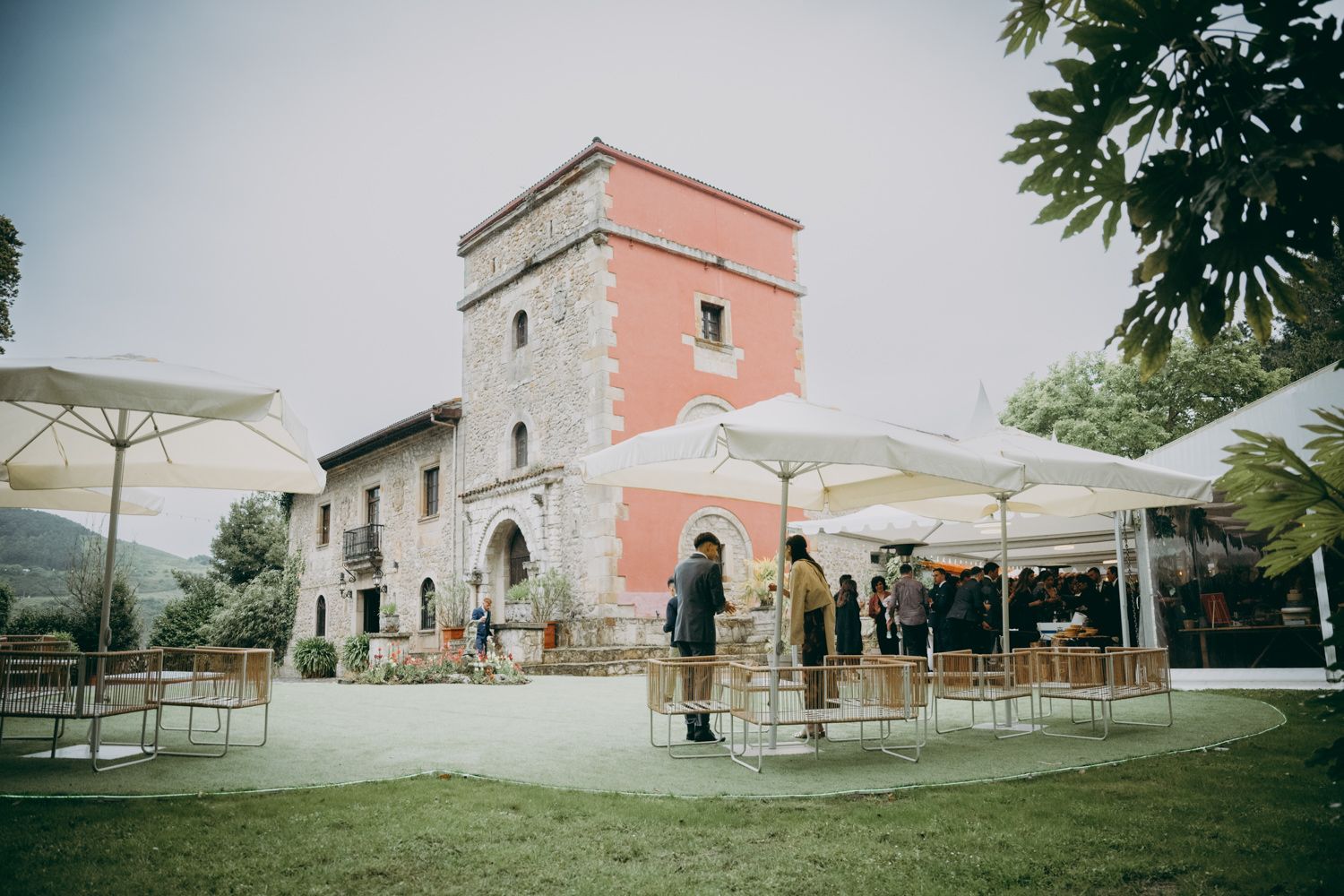 El Palacio de Villabona con sombrillas blancas y zona de estar al aire libre.