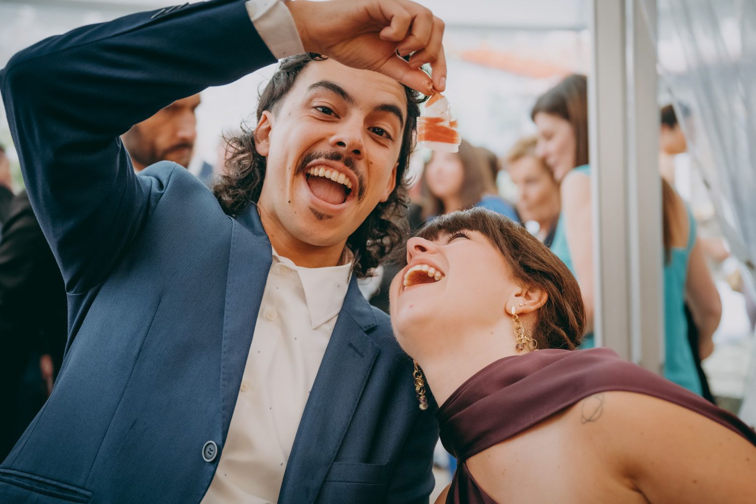 Los invitados se divierten en un evento de celebración bajo una carpa.