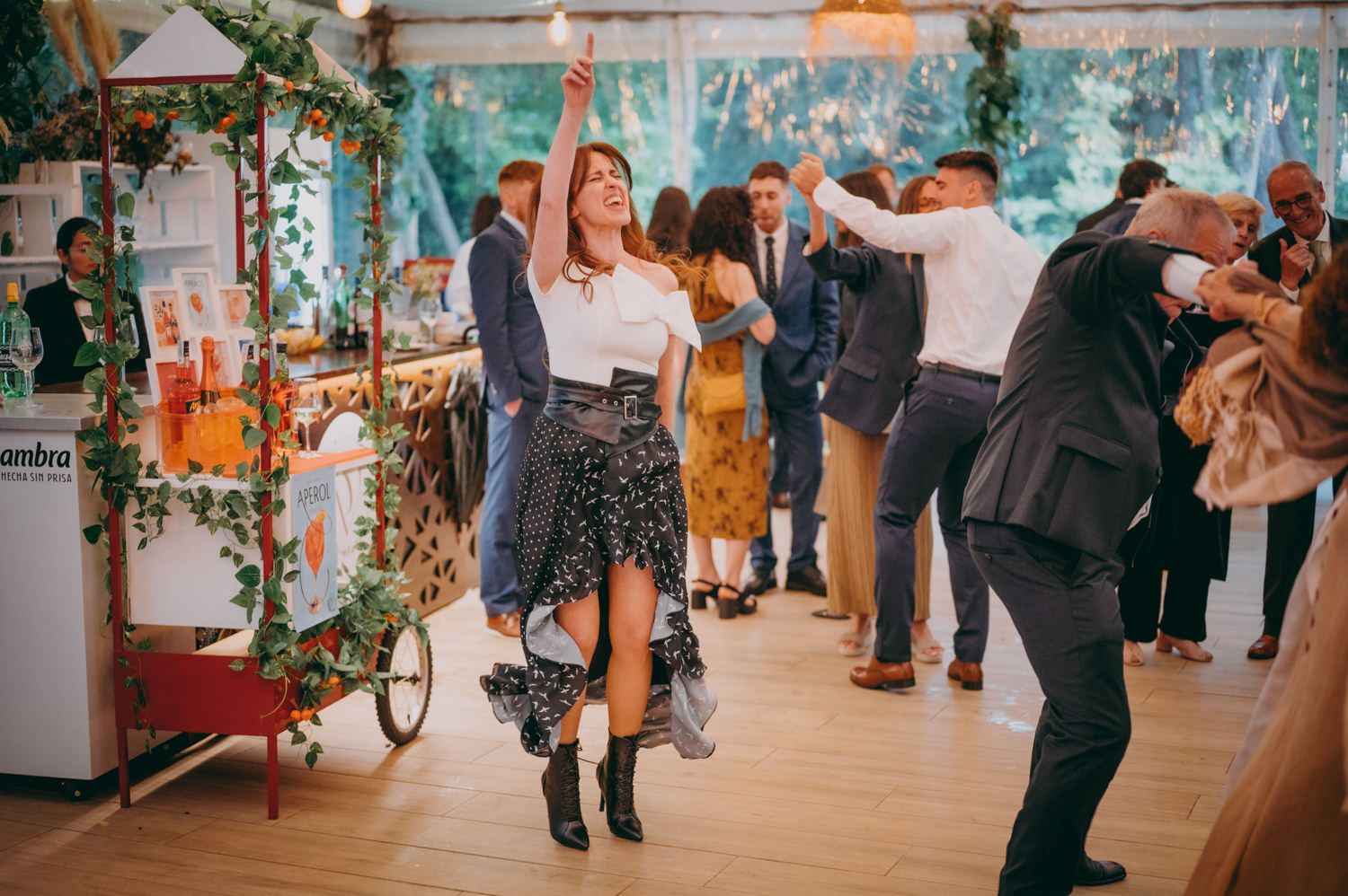 Parejas bailando en una recepción de boda en un interior decorado con vegetación y paredes azules en el palacio de Villabona
