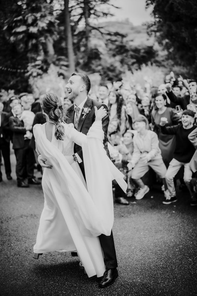 Los recién casados comparten su primer baile al aire libre mientras los invitados a la boda animan y celebran.