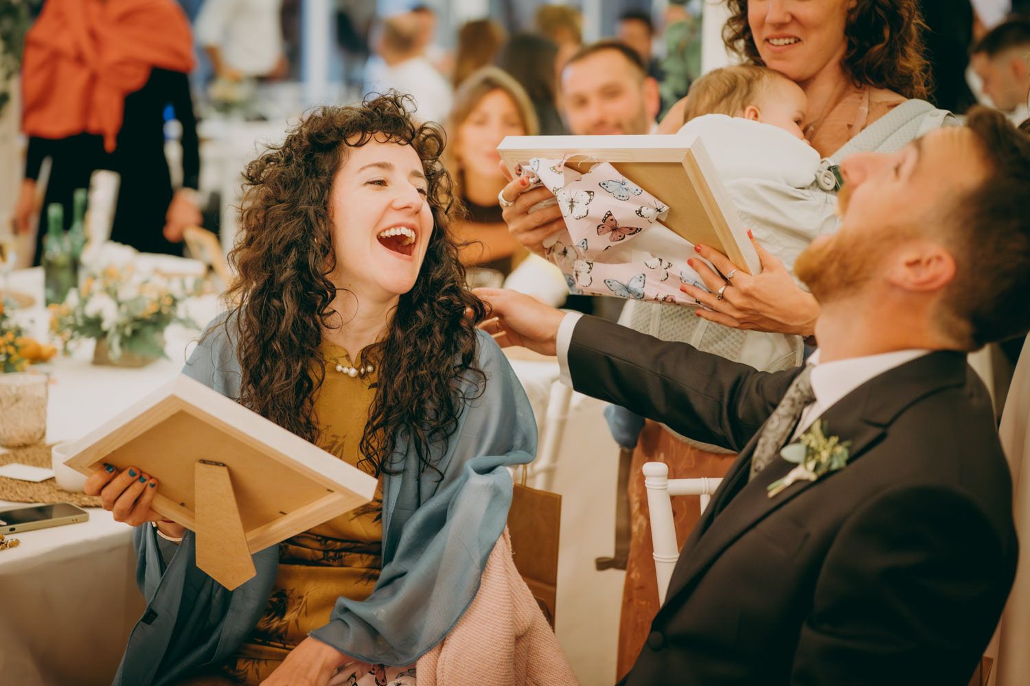 Los invitados a la boda comparten un momento alegre mientras leen los libros de menú en una celebración de recepción en el interior.