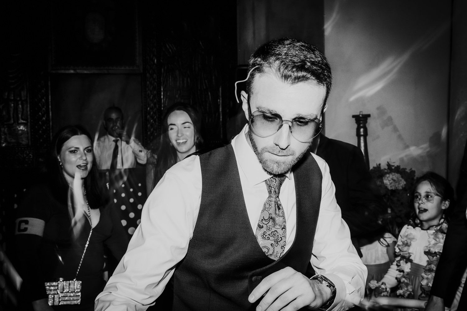 Fotografía espontánea en blanco y negro de invitados festejando y disfrutando de un evento en los interiores del Palacio de Villabona.