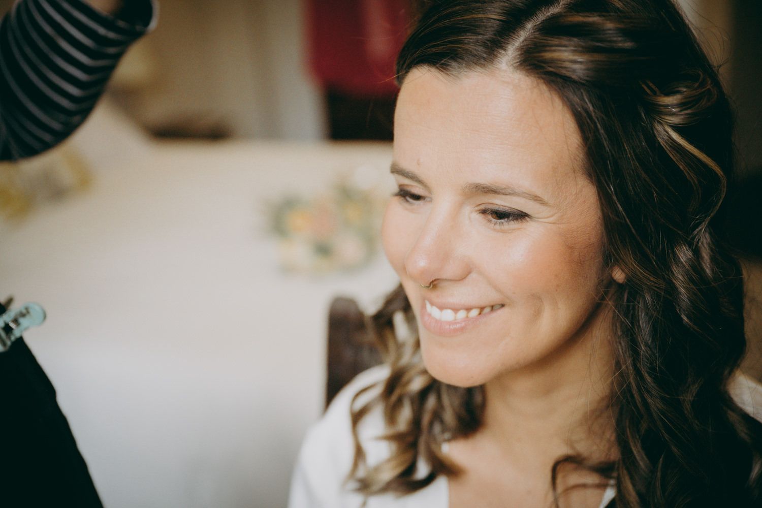 Preparándose con maquillaje profesional, bata blanca y suave iluminación natural.