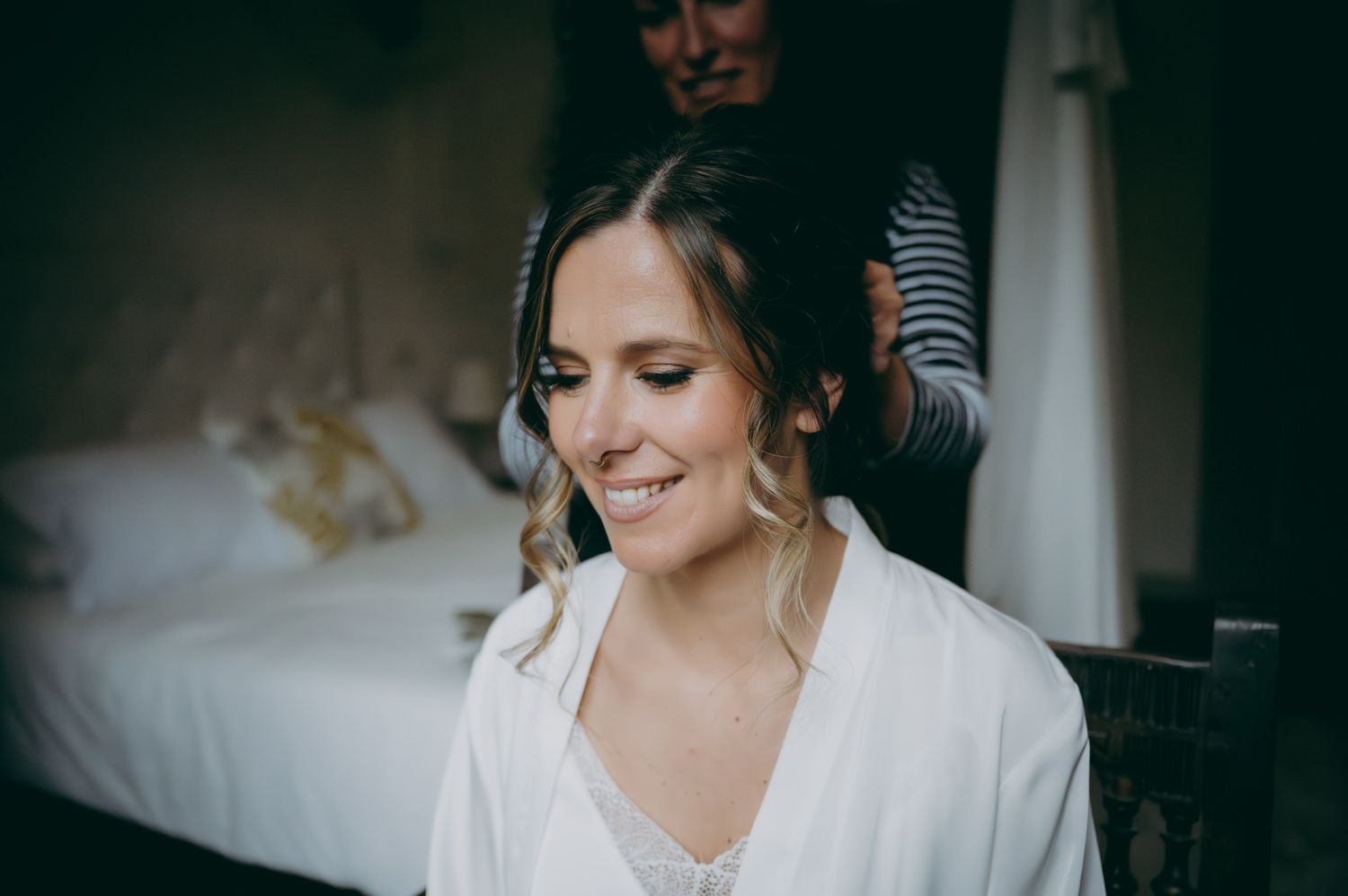 Una novia se sienta mientras le peinan el cabello en preparación para un evento.