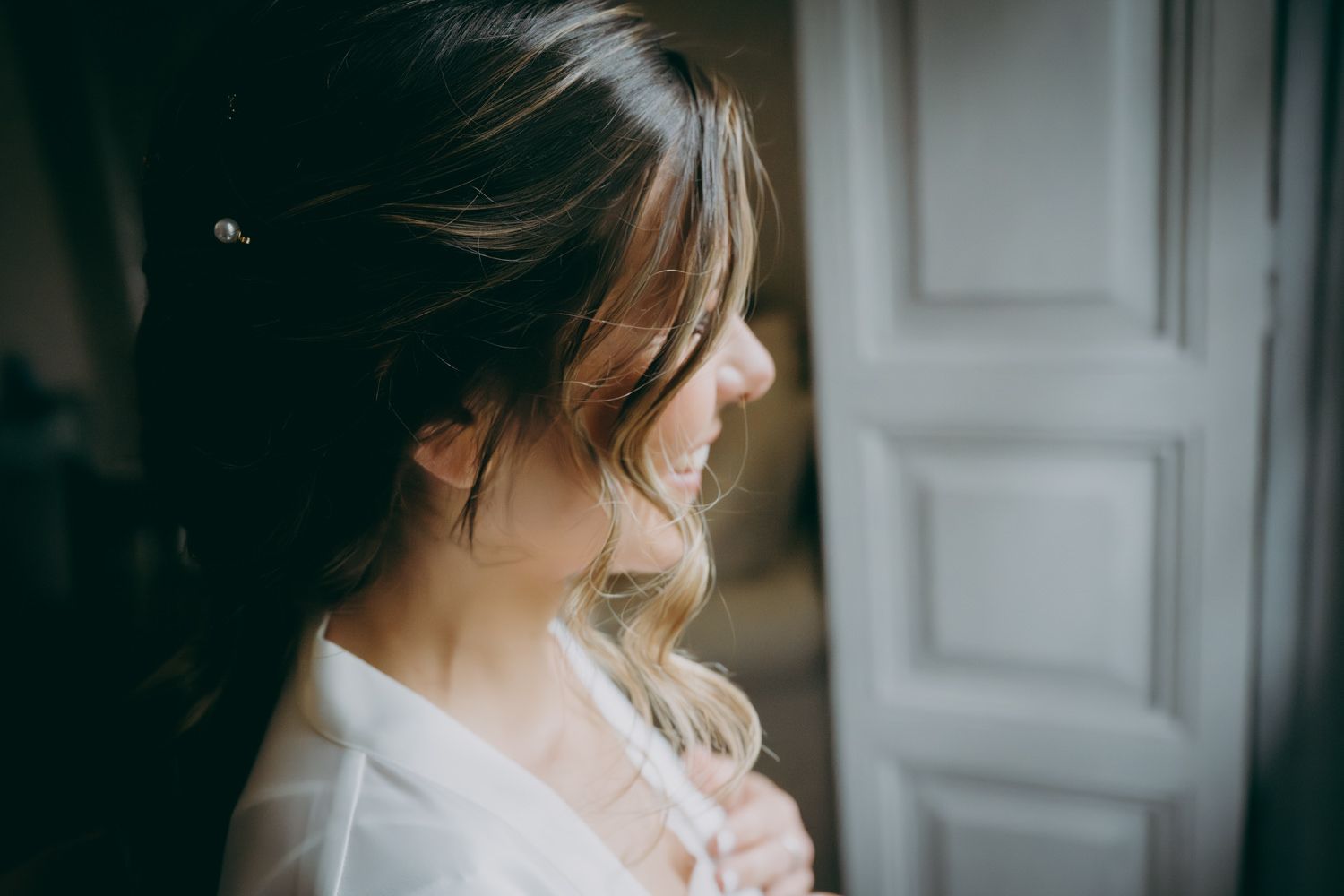 Una foto de perfil lateral de alguien con cabello peinado y una túnica blanca.