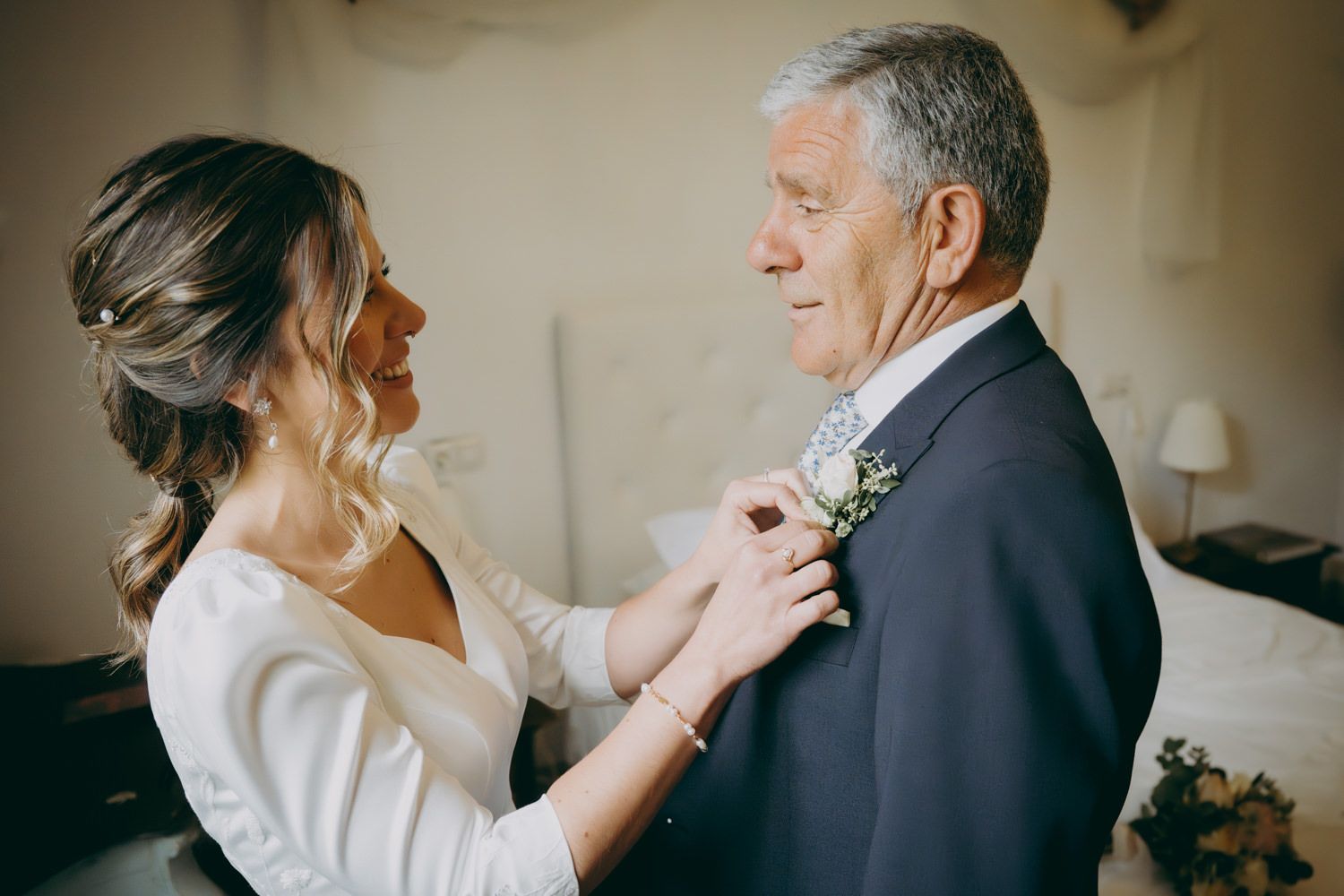 Dulce momento de preparativos con un boutonniere colocado en un traje formal.