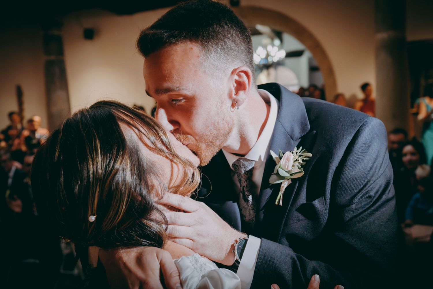 Momento íntimo compartido entre los recién casados durante su primer beso en la ceremonia nupcial.