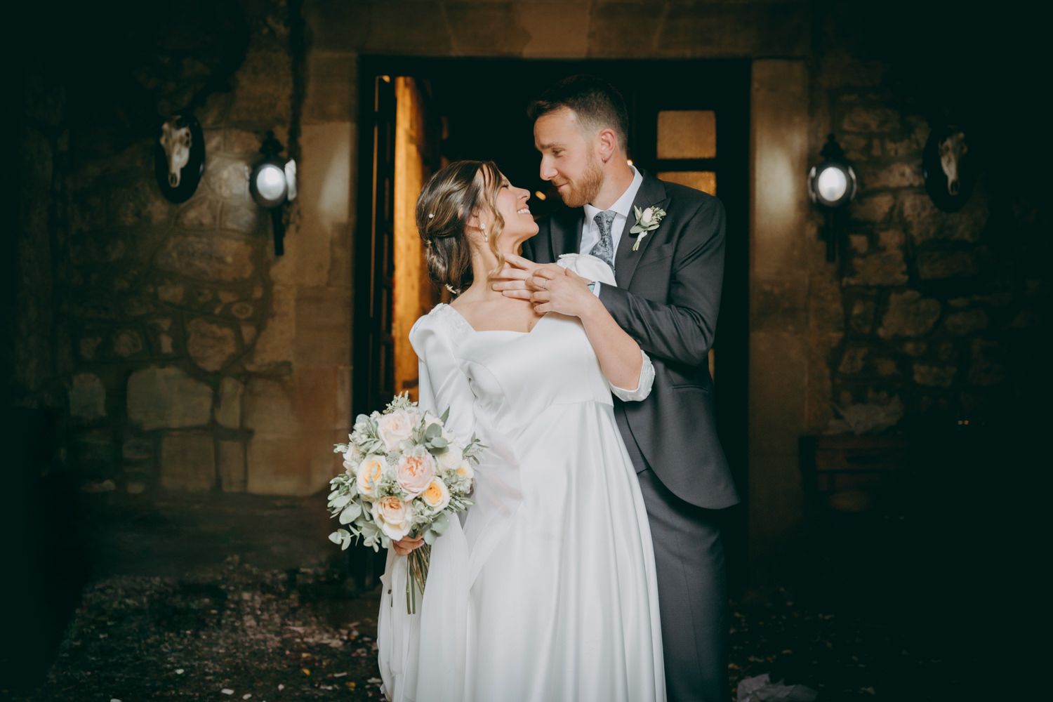 Una pareja de novios se abrazan en un retrato vespertino frente al Palacio de Villabona.