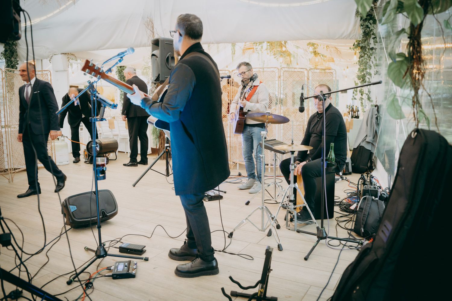 Banda de bodas tocando en el escenario con instrumentos y micrófonos en el lugar de la recepción