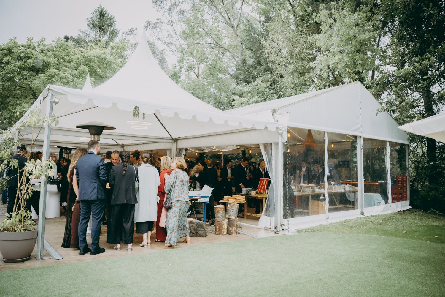 Carpas blancas para eventos instaladas sobre un césped verde con invitados reunidos afuera del palacio de Villabona.