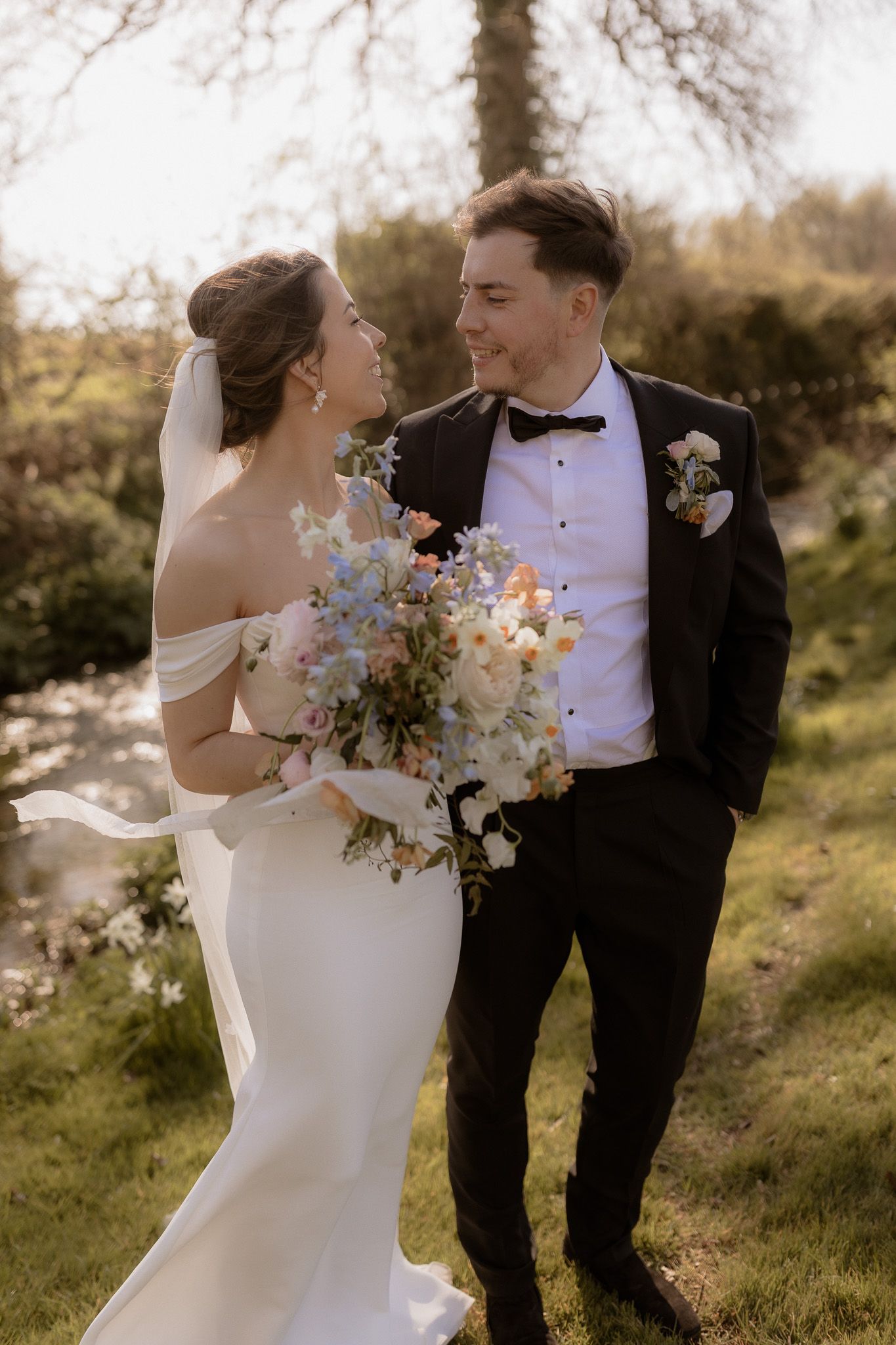 Romantic outdoor portrait of couple with spring flowers and natural scenery.